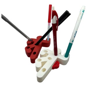 May include: A white and red desk organizer shaped like a person holding a pen. The organizer has multiple slots for pens, pencils, and other office supplies.