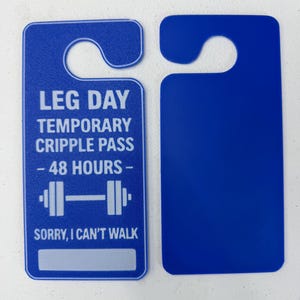 K&ouml;nnte beinhalten: Zwei blaue T&uuml;ranh&auml;nger. Einer hat den Text "LEG DAY TEMPORARY CRIPPLE PASS - 48 HOURS -" mit einer Hantel-Grafik und "SORRY, I CAN'T WALK." Der andere ist einfarbig blau.