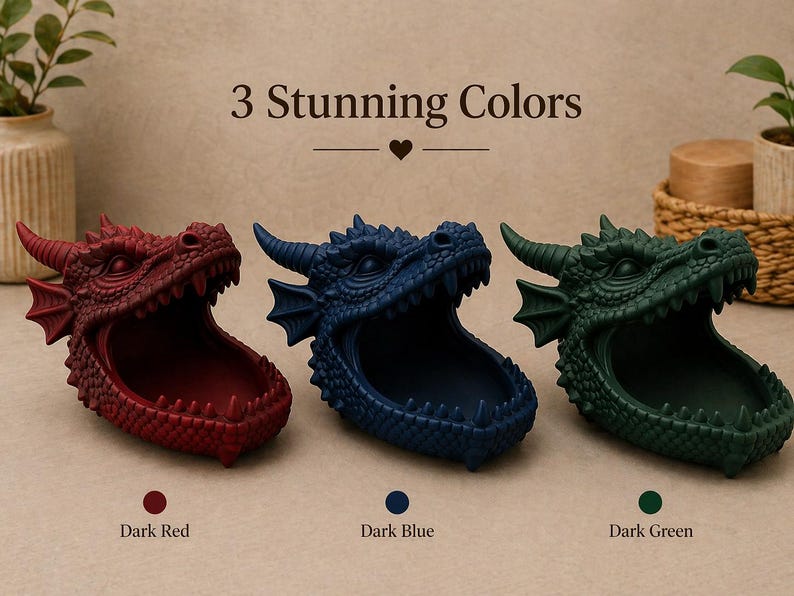 May include: Three dragon head-shaped containers in dark red, dark blue, and dark green. The containers have open mouths and are displayed on a light surface. The text "3 Stunning Colors" is above the containers.