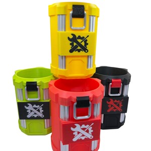 May include: A collection of four cylindrical containers in yellow, lime green, red, and black. Each container features vertical silver-colored accents, a black or red latch mechanism, and a central rectangular patch displaying a gear and wrench icon.