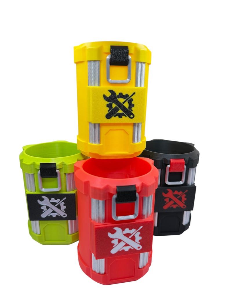 May include: A collection of four cylindrical containers in yellow, lime green, red, and black. Each container features vertical silver-colored accents, a black or red latch mechanism, and a central rectangular patch displaying a gear and wrench icon.