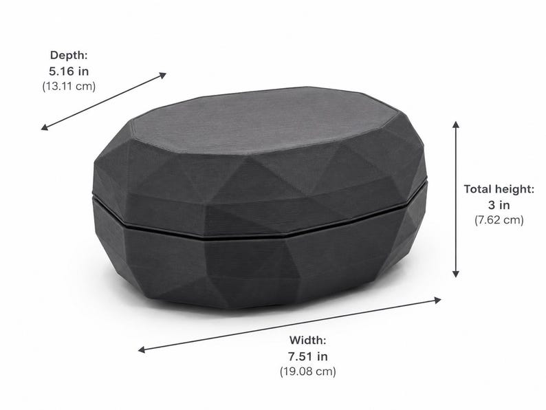 Puede incluir: Una caja negra de forma geom&eacute;trica con un dise&ntilde;o facetado. La caja mide 19,08 cm de ancho, 13,11 cm de profundidad y 7,62 cm de alto. La caja est&aacute; hecha de un material oscuro y tiene tapa.