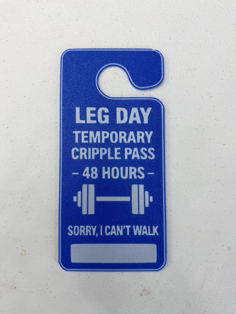 K&ouml;nnte beinhalten: Blauer T&uuml;rh&auml;nger mit dem Text "LEG DAY TEMPORARY CRIPPLE PASS - 48 HOURS -" und einer Hantelgrafik. Auf dem unteren Teil des Anh&auml;ngers steht "SORRY, I CAN'T WALK."