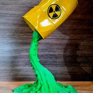 May include: A yellow barrel, marked with a black radiation symbol, is depicted pouring out a stream of bright green liquid. The liquid forms a pool at the base, creating a decorative piece.
