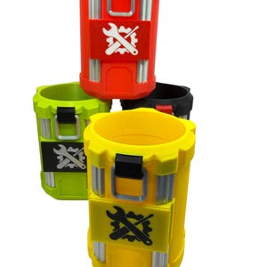 May include: A collection of four cylindrical containers in red, yellow, lime green, and black. Each container features vertical silver-colored accents, a black top handle, and a central rectangular patch displaying a white or black wrench and gear icon.