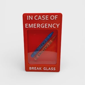 May include: A rectangular red plastic display case with a clear front window. The text IN CASE OF EMERGENCY is printed at the top and BREAK GLASS at the bottom in white. Inside, two wax crayons, one blue and one brown, are positioned diagonally.