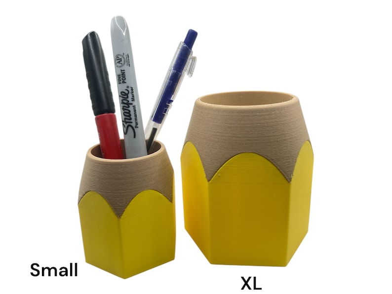 May include: Two yellow pencil-shaped desk organizers, one labeled "Small" and the other labeled "XL". The smaller organizer has two pens inside, one red and one black.