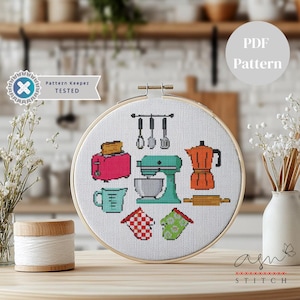 Può includere: Un telaio da ricamo a punto croce con icone a tema cucina: un tostapane rosa, un mixer da cucina turchese e una caffettiera arancione. Il testo "PDF Pattern" è visibile. Il testo "Pattern Keeper Tested" è visibile.
