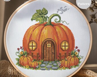 May include: A cross-stitch pattern of a pumpkin house with a wooden door, windows, and a green vine. The design includes pumpkins, flowers, and the text "PDF Pattern" and "Pattern Keeper Tested". The embroidery is set in a wooden hoop.