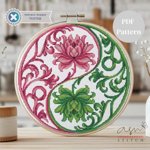 Puede incluir: Bordado de punto de cruz en un aro de madera. El diseño presenta una composición de yin-yang con un elemento floral rosa en un lado y un elemento floral verde en el otro. El texto "Pattern Keeper TESTED" y "PDF Pattern" son visibles.