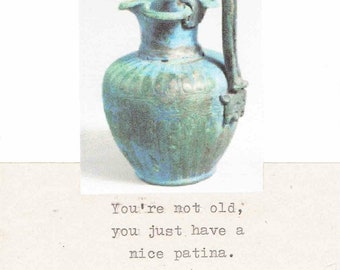 May include: A blue and green ceramic jug with a handle. The text "You're not old, you just have a nice patina." is below the jug.