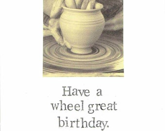 May include: A black and white photograph of a hand shaping clay on a pottery wheel. The text "Have a wheel great birthday." is below the image.