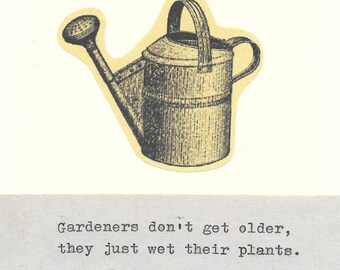 May include: A vintage-style illustration of a watering can, set against a cream-coloured background. The watering can is grey and has a handle and a spout. Below the image is the text: "Gardeners don't get older, they just wet their plants."