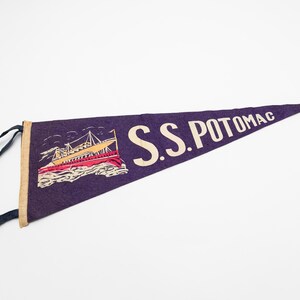 May include: Purple pennant with the text "S.S. POTOMAC" in white. The pennant features an illustration of a ship with red, yellow, and white details. The pennant has a tan border and black ties.