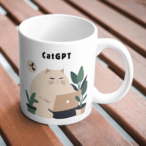 Könnte beinhalten: Weiße Keramiktasse mit einer Comic-Katze, die eine Brille trägt und einen Laptop benutzt. Die Tasse hat den Text "CatGPT" aufgedruckt.