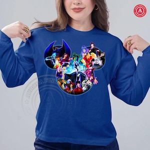 K&ouml;nnte beinhalten: Ein k&ouml;nigsblaues Langarm-Sweatshirt mit einer Grafik von Disney-B&ouml;sewichten in Form des Kopfes von Mickey Mouse. Die Grafik zeigt Charaktere wie Ursula, Maleficent und Cruella de Vil. Das Sweatshirt hat einen Rundhalsausschnitt und ist aus weichem Material.