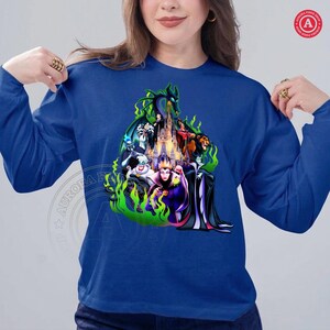 Puede incluir: Una sudadera de manga larga azul real con un gr&aacute;fico colorido de villanos de Disney, incluyendo Mal&eacute;fica y la Reina Malvada, con un castillo de fondo y llamas verdes.