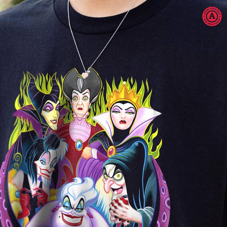 May include: Black t-shirt featuring a colorful graphic of several Disney villains, including Ursula, the Evil Queen, and Maleficent. A silver necklace with a heart pendant is visible. The shirt has a round, red logo in the upper right corner.