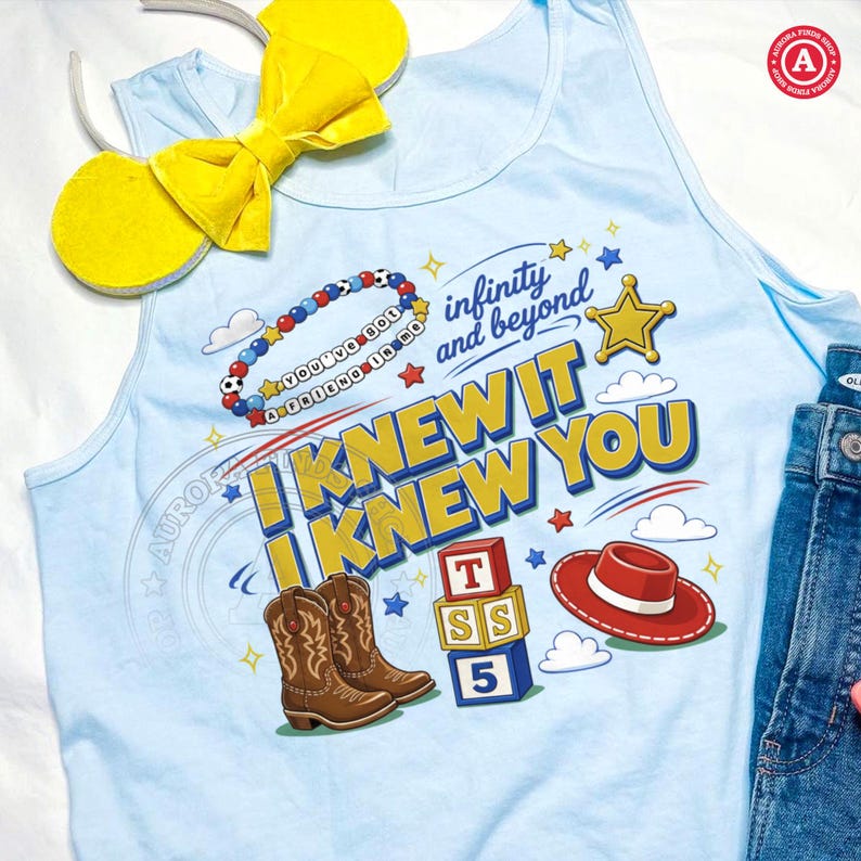 Puede incluir: Una camiseta sin mangas azul claro con un estampado gr&aacute;fico con el texto "I KNEW IT I KNEW YOU" e "infinity and beyond". El dise&ntilde;o incluye una pulsera de cuentas, una estrella dorada, botas vaqueras marrones, bloques y un sombrero rojo.