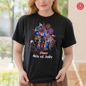May include: Black t-shirt featuring a colorful graphic of a castle, fireworks, and various characters. The text "Happy 4th of July" is displayed below the graphic. The design includes an American flag.