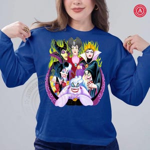 May include: Royal blue long-sleeve shirt featuring a colorful graphic of Disney villains. The design includes characters like Maleficent, the Evil Queen, and Ursula. The graphic is set within a purple and black circular frame.