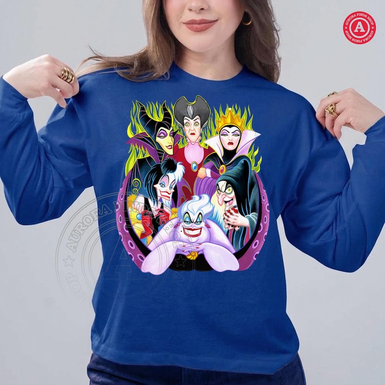 May include: Royal blue long-sleeve shirt featuring a colorful graphic of Disney villains. The design includes characters like Maleficent, the Evil Queen, and Ursula. The graphic is set within a purple and black circular frame.