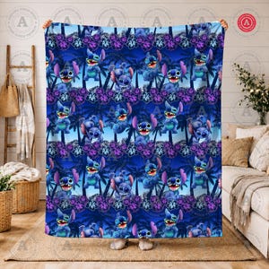 Puede incluir: Una manta azul con un patr&oacute;n repetido del personaje Stitch de Lilo & Stitch, palmeras y flores moradas. La manta tiene un fondo azul oscuro con el texto "AURORA FINDS SHOP" en un patr&oacute;n circular. La manta est&aacute; sujeta por una persona.