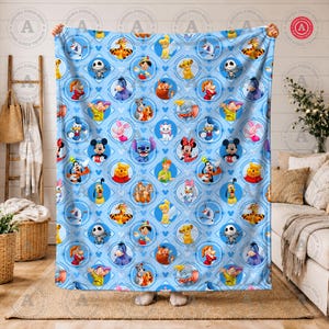 May include: A light blue blanket featuring a repeating pattern of various Disney characters within diamond-shaped frames. Characters include Mickey Mouse, Winnie the Pooh, and Stitch. The blanket is held up by two hands.