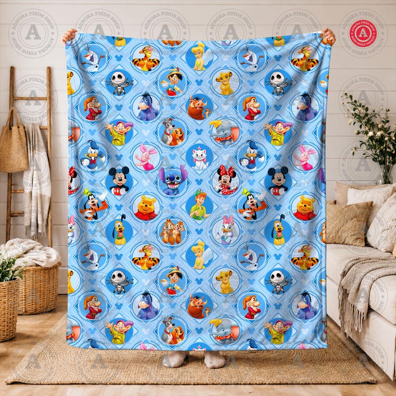 May include: A light blue blanket featuring a repeating pattern of various Disney characters within diamond-shaped frames. Characters include Mickey Mouse, Winnie the Pooh, and Stitch. The blanket is held up by two hands.