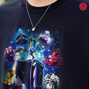 May include: Black t-shirt with a vibrant graphic of Disney villains such as Maleficent and Ursula, set against a starry backdrop. A silver necklace with a heart-shaped pendant is visible.