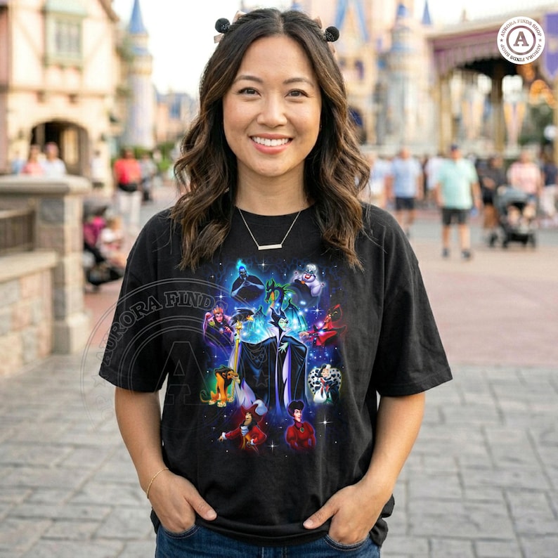 May include: Black t-shirt with a vibrant graphic showcasing Disney villains, including Maleficent and Cruella de Vil. The design features a starry backdrop and a collection of iconic characters. The shirt has a crew neck and short sleeves.