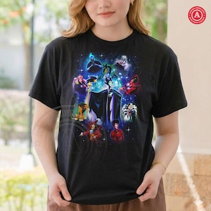 May include: Black t-shirt with a vibrant graphic of animated villains, including Maleficent, Cruella de Vil, and the Evil Queen. The design is set against a dark background. The t-shirt has a crew neck and short sleeves.
