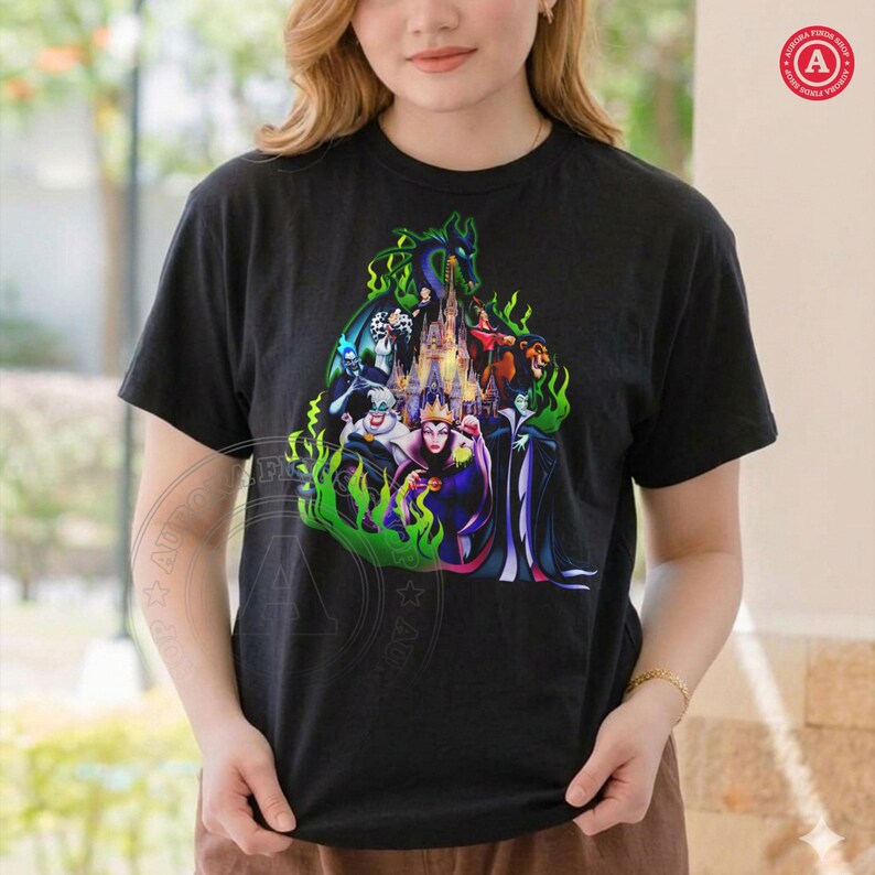 Puede incluir: Camiseta negra con un gr&aacute;fico colorido de villanos de Disney, incluyendo a la Reina Malvada y Mal&eacute;fica, con un castillo de fondo. El dise&ntilde;o est&aacute; rodeado de llamas verdes.