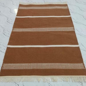 : Corner view of the rug highlighting the fringe and stitching.