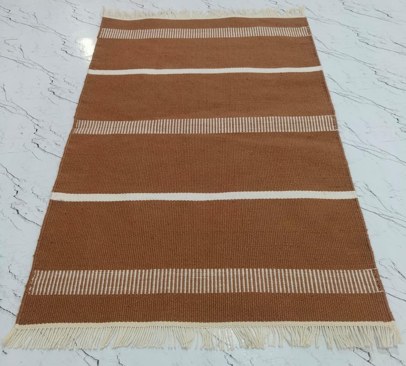 : Corner view of the rug highlighting the fringe and stitching.
