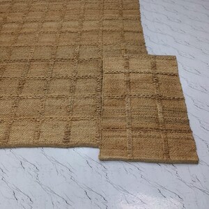 Overhead view of the checkered jute rug laid flat showcasing pattern details.