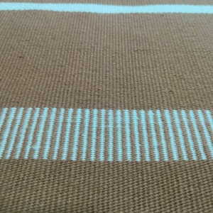 Side-angle shot showing thickness, durability, and flatweave construction.