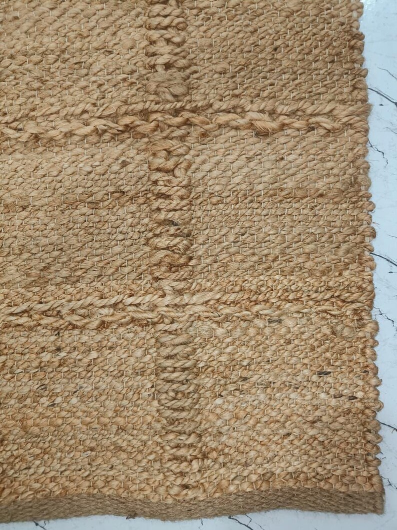 Rolled natural jute rug showing thickness and durable flatweave construction.