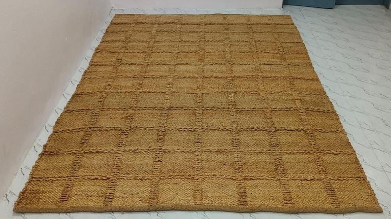 Handwoven natural jute rug with textured checkered design displayed in a modern living room.