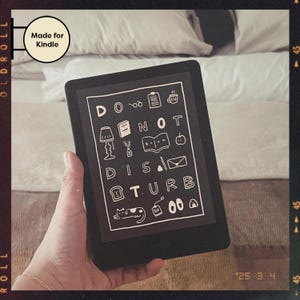 May include: A black and white Kindle e-reader with a white background displaying a graphic that says "DO NOT DISTURB" with various illustrations of books, coffee cups, and other reading-related items.