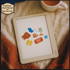 Könnte beinhalten: Ein weißer E-Reader mit einem beigefarbenen Bildschirm, auf dem bunte Aufkleber zu sehen sind. Die Aufkleber zeigen eine karierte Decke, eine Tasse Kaffee, eine Lampe, ein Paar blaue Hausschuhe und einen roten Aufkleber mit der Aufschrift "Night Owl".