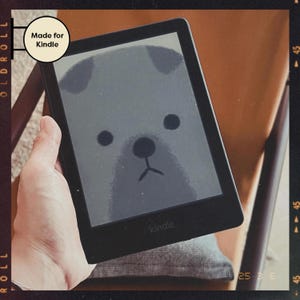 May include: A black Kindle e-reader with a cartoon pug on the screen. The screen says "kindle" at the bottom. The text "Made for Kindle" is visible in the top left corner of the image.
