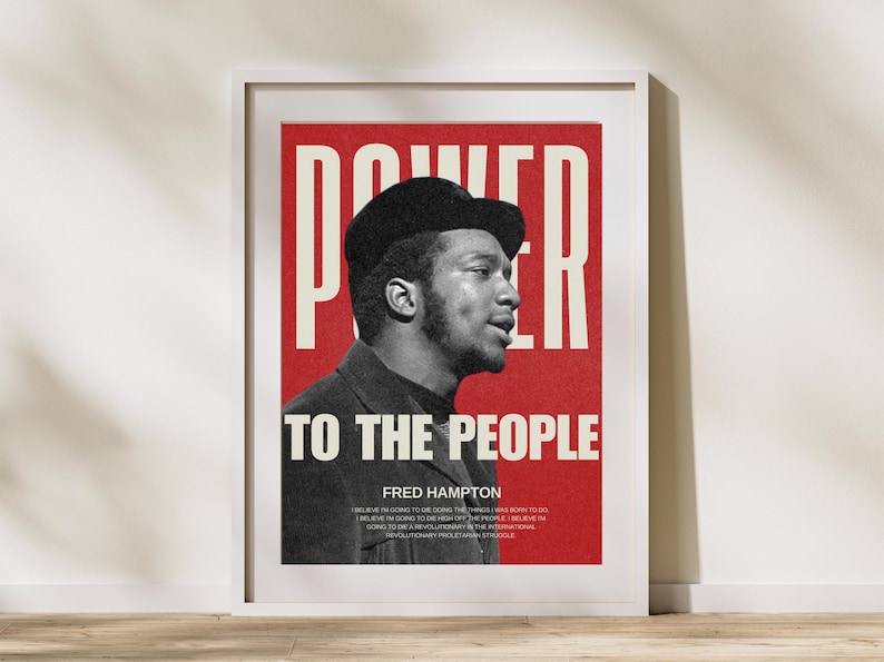 Framed Fred Hampton "Power to the People" print on a wooden desk with neutral decor. Bold red and black activist wall art for modern and minimalist interiors. Perfect for social justice enthusiasts and history lovers.