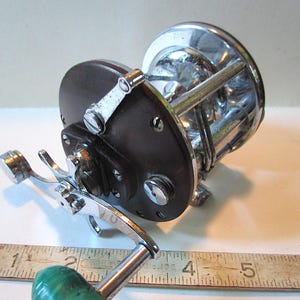 2 old fishing reels penn Squall II Lever Drag Conventional Proprietary CNC Gear Technology and HT Penn Battle II Spinning Reel,
