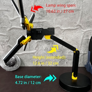 The Death Stranding inspired folding LED lamp is a stylish and practical addition to any space. With its futuristic design, this lamp features an adjustable structure that can be posed in various ways to suit your lighting needs. Made with high-quality PLA material, this 3D printed lamp showcases durability and attention to detail. The unique color combination of yellow, black, and metallic silver ties back to the Bridges organization seen in the Death Stranding game