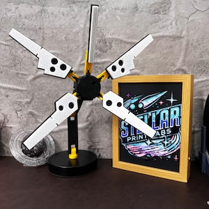 Death Stranding inspired 3D printed folding LED lamp designed with industrial aesthetics, featuring adjustable arms and joints for customizable lighting angles. This USB powered lamp combines futuristic tech-inspired design with practicality, making it perfect for both gamers and collectors. The lamp is made from durable PLA plastic, ensuring long-lasting use. The unique yellow, black, and metallic silver color scheme reflects the Bridges aesthetic from the popular video game