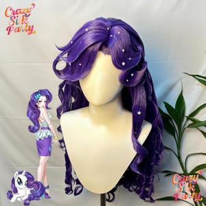 Puede incluir: Una vibrante peluca morada con largos rizos sueltos y delicados detalles de perlas. La peluca está peinada sobre una cabeza de maniquí, mostrando su intrincado diseño. La imagen también incluye una ilustración de dibujos animados de un personaje con un cabello morado similar. El logotipo de Crazy Silk Party es visible.