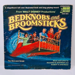 May include: Vintage vinyl record album cover for "Bedknobs and Broomsticks" from Walt Disney Productions. The cover features a colorful illustration of characters on a flying bed against a dark blue background. The album is a stereophonic Disneyland record.
