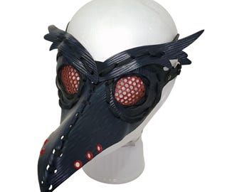 May include: A black leather plague doctor mask with red mesh eye coverings and a long beak. The mask is on a white mannequin head.