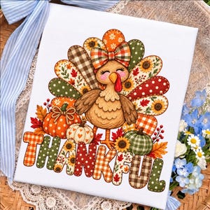 May include: A white canvas print featuring a cartoon turkey with a plaid bow, surrounded by pumpkins and autumn leaves. The word THANKFUL is written in large, patterned block letters at the bottom, incorporating sunflowers, polka dots, and plaid designs.